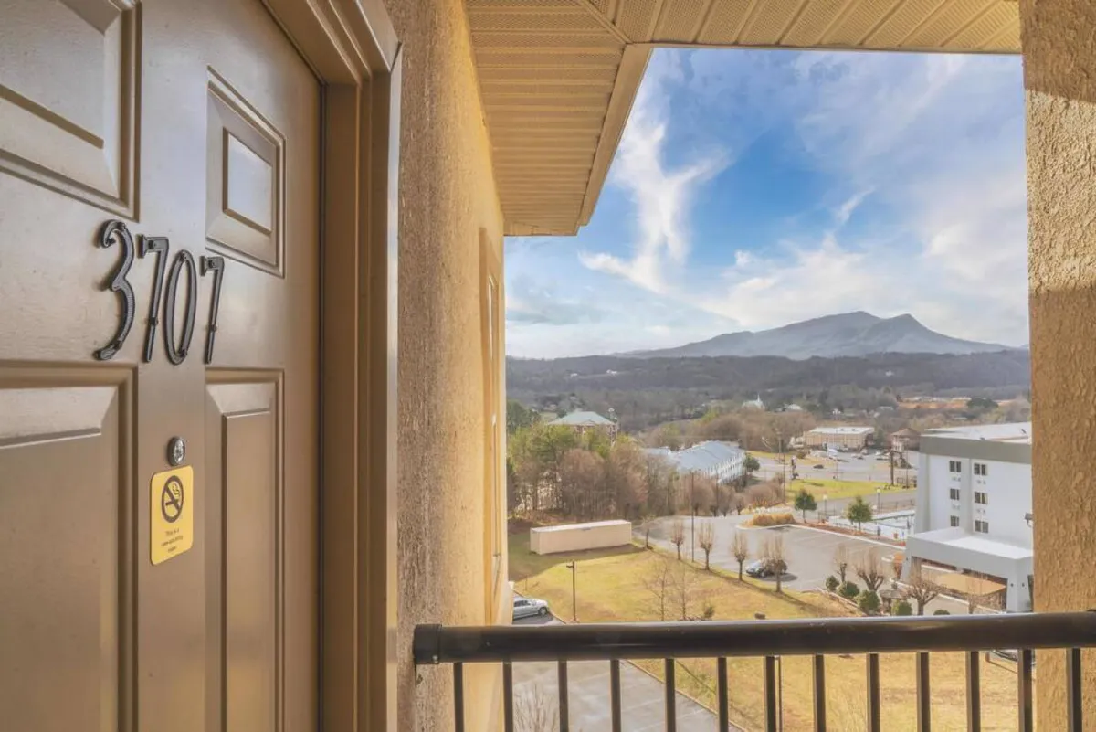 A view of the entryway door (number 3707) with a stunning mountain backdrop and surrounding landscape. The photo conveys both the sense of arrival and the top-floor location, with mountains visible beyond, setting the tone for a serene stay.